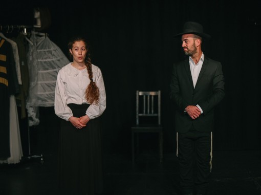 חרדי צעיר במגבעת מביט בחיוך בחרדית צעירה בצמה ארוכה