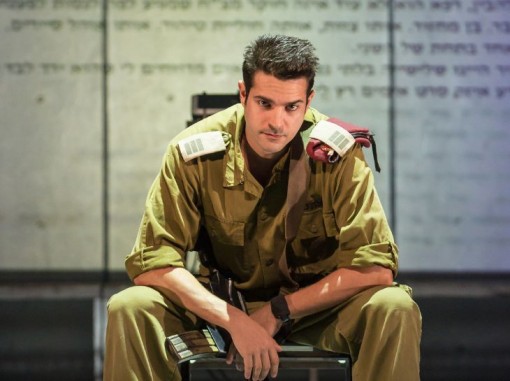 קצין יושב עם נשקו נראה מיואש