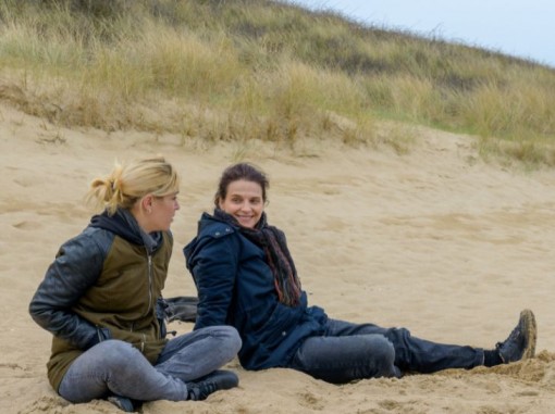 שתי נשים יושבות בחוף ומשוחחות