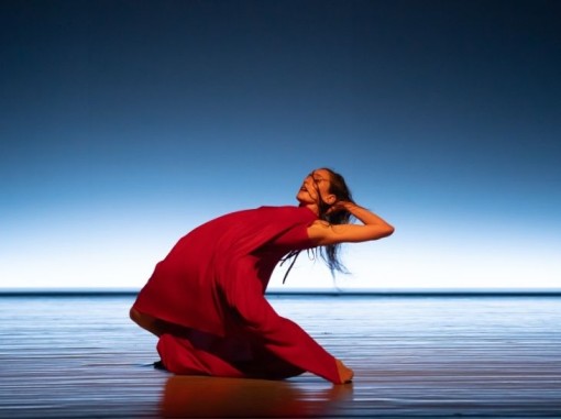 רקדנית בשמלה אדומה רוקדת בים
