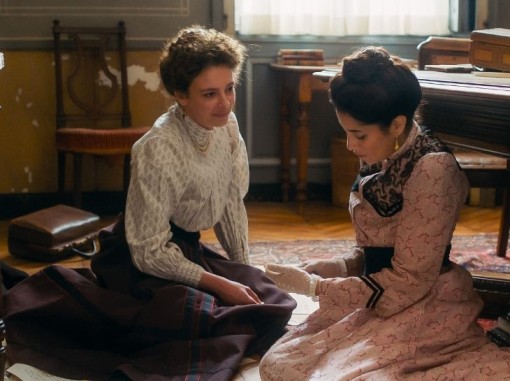 שתי נשים צעירות בלבוש תקופתי יושבות על הרצפה