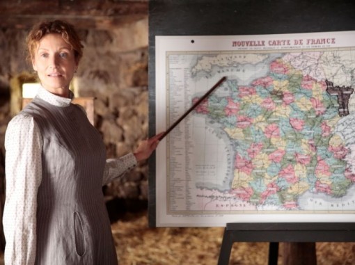 מורה מצביעה עם מקל על מפת צרפת