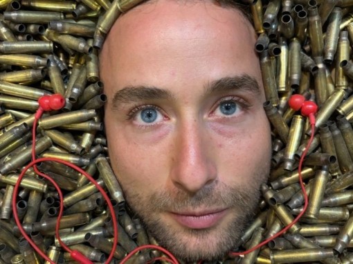 תקריב פני חייל מוקף בקליעי ירי ובאוזניות