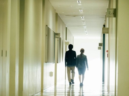 צעיר וצעירה פוסעים במסדרון גבם למצלמה